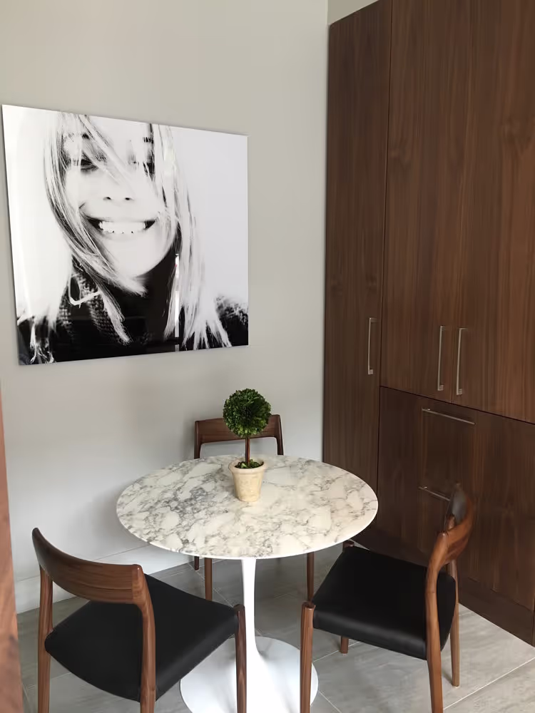 Cozy consultation corner at Smilebar featuring marble table and large smiling portrait
