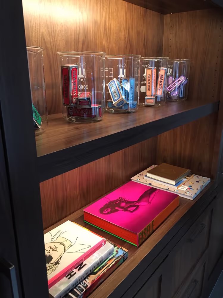 Smilebar shelf display with design books and jars filled with Marvis toothpaste tubes